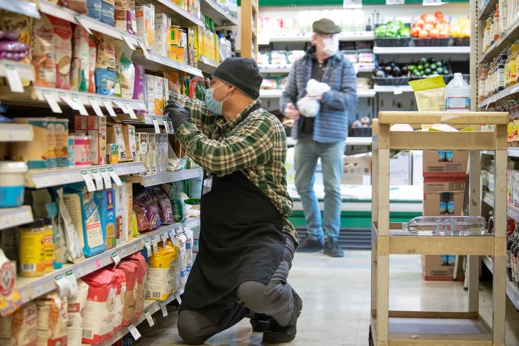 A shopper comparing products in a grocery aisle