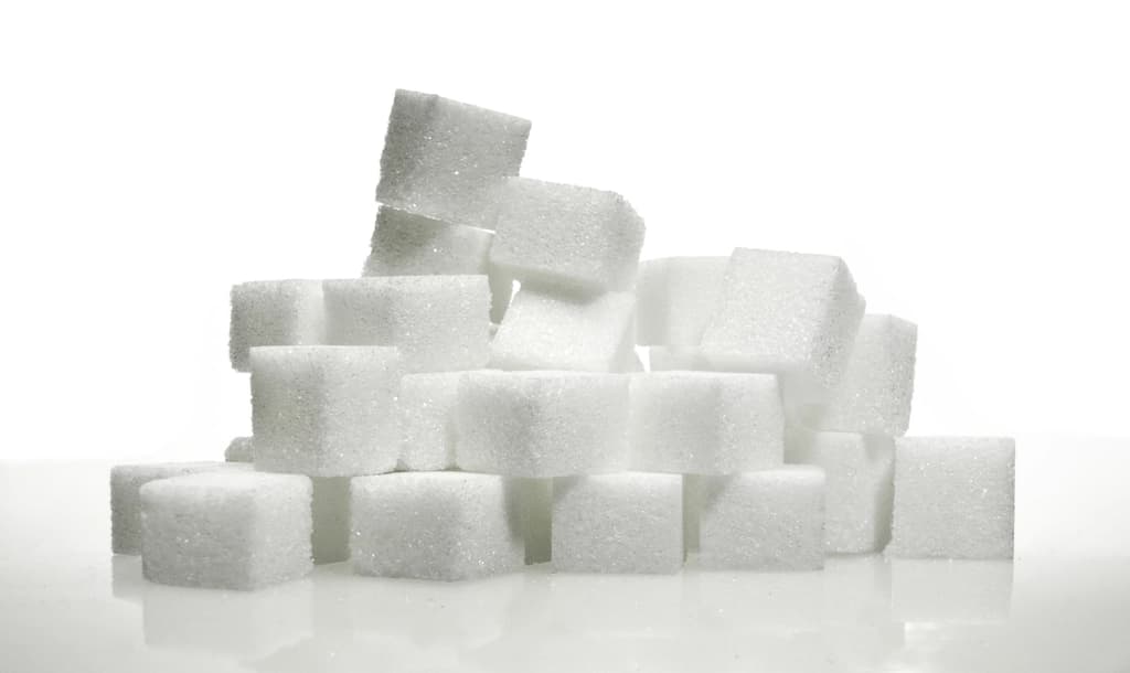 Sugar cubes and a spoonful of white sugar