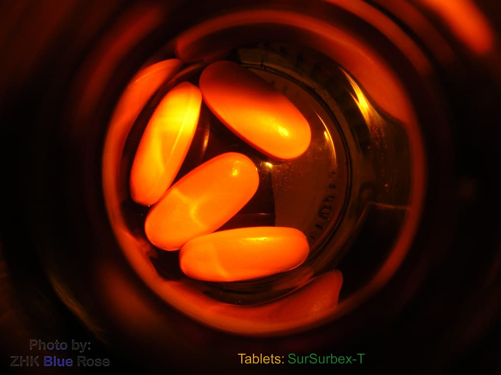 Multivitamin tablets beside their bottle